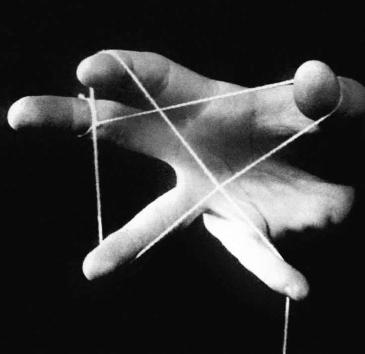 Main en noir et blanc tenant des fils tendus comme ceux d'une marionnette