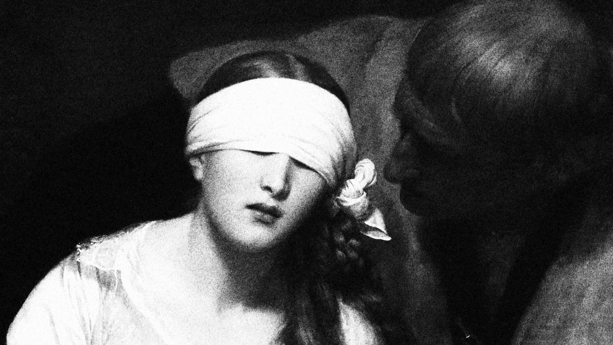 femme aux yeux bandés et homme en noir qui la regarde comme pour vérifier qu'elle ne voit rien
